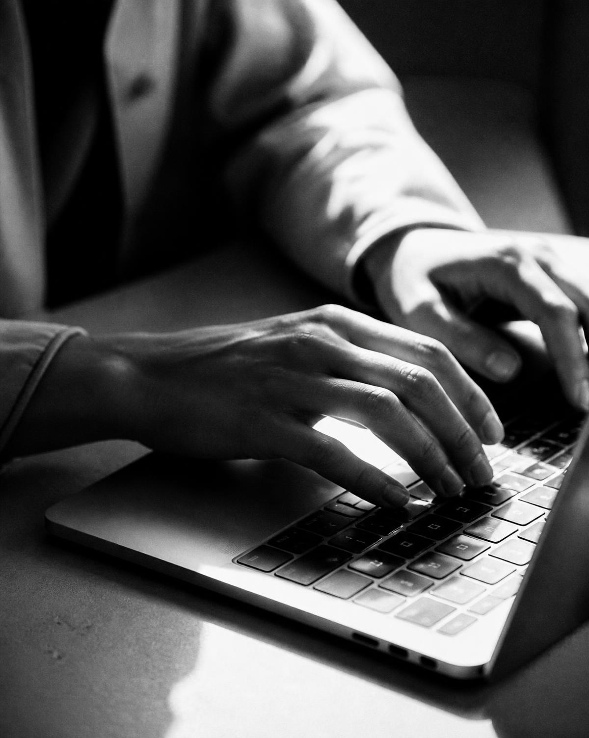 Close crop of hands working at a laptop